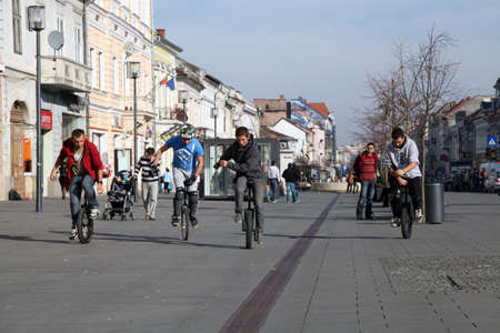 young men riding monocycles on a street in romaniaのeditorial素材
