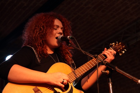 young woman playing guitar in a concert in romaniaのeditorial素材