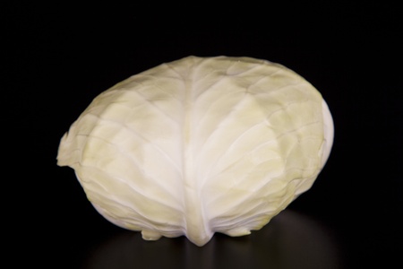 cur in half white cabbage isolated on a black backgroundの写真素材