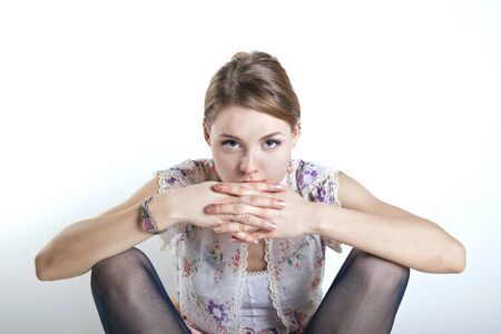 young gorgeous woman staring at the camera with hands over mouthの写真素材