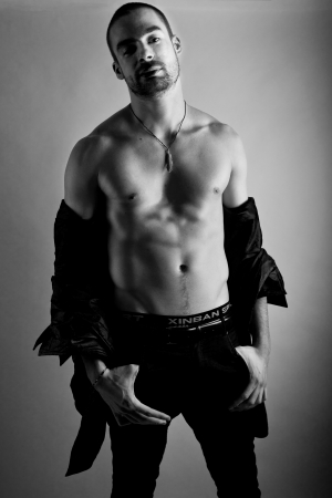 young sexy man posing with uunbuttoned shirt on black and white backgroundの写真素材
