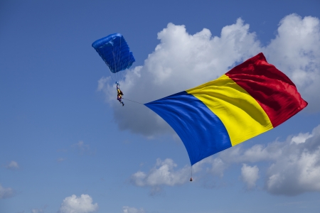 parachute skydiver with huge romanian flag hanging from himの写真素材