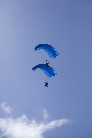 open parachute skydivers on a clear blue sky standing on top of eache otherの写真素材