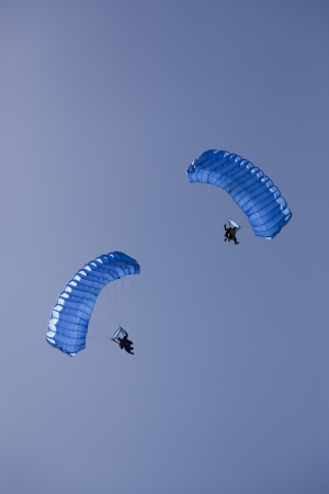 open parachute skydivers on a clear blue skyの写真素材
