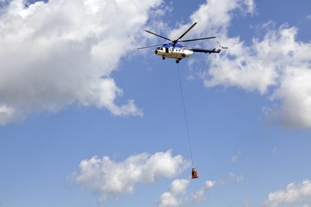 helicopter in the air carrying a human cargo on a ropeのeditorial素材