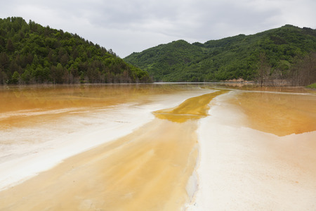POluted lake in the mountains from a mine in romaniaの写真素材