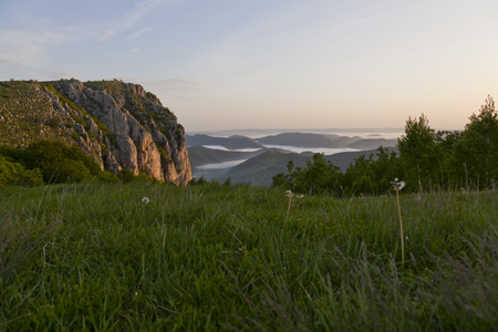 mountains in romania with fog and bright colours at sunriseの写真素材