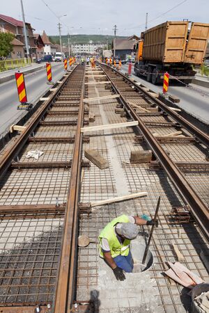 railway construction worker in a hole in the street with trafficの写真素材