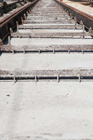 new railway track with concrete drops and dirty metalの写真素材