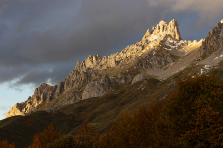 Autumn landscape of Picos de Europa natinal park mountain range in Spain with bright forest leaves and sunsetの写真素材