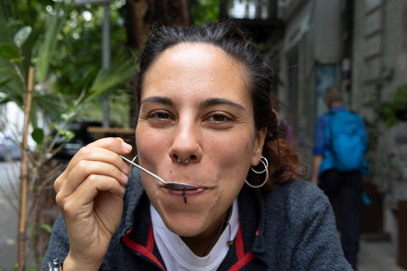 Portrait of young hispanic woman drinking coffee outside alone smilingの写真素材
