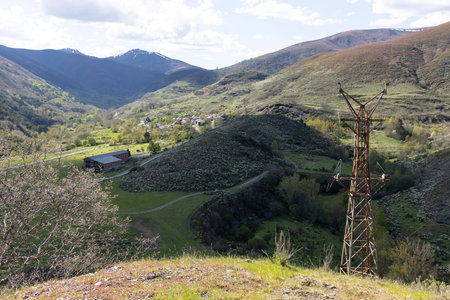 Abandoned steel structure with towers from industrial coal mining cableway in mountains of Asturias Spain in Tormaleo on a sunny spring day with flowersの写真素材