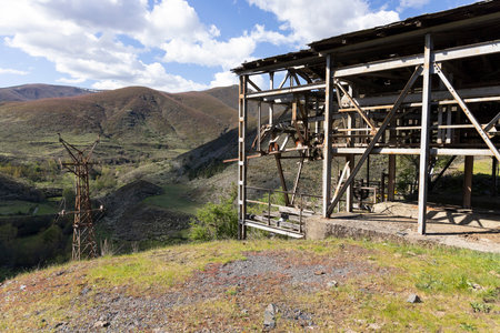 Abandoned steel structure with towers from industrial coal mining cableway in mountains of Asturias Spain in Tormaleo on a sunny spring day with flowersの写真素材