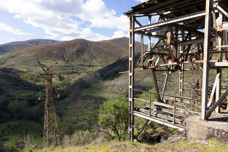 Abandoned steel structure with towers from industrial coal mining cableway in mountains of Asturias Spain in Tormaleo on a sunny spring day with flowersの写真素材