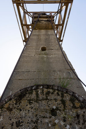Steel metal cable next to old abandoned mining tower structure on a bright sunny day.の写真素材