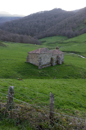 Chapel in green meadow on a bright sunrise in Ponga natural park in Spain.の写真素材