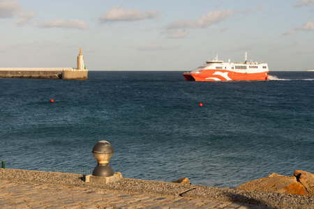 Boat in the ocean water crossing Gibraltar Strait from  Morocco to Tarifa in Spain next to statue of Jesus on a bright sunny day with blue sky and clear water.の写真素材