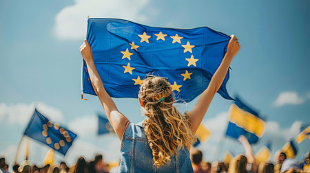 Portrait of happy woman holding european union flag europe democracy sign from behind politics celebration conceptの素材