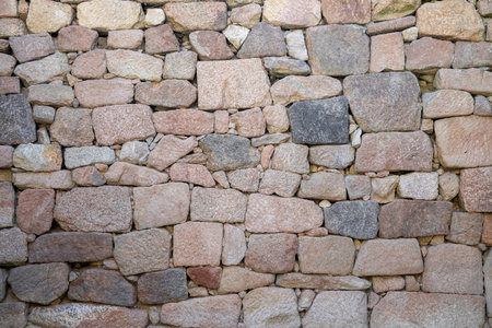 An intriguing composition of an intricately arranged stone wall highlighting variable textures and colors, reflecting the harmony of ancient craftsmanship and nature.の写真素材