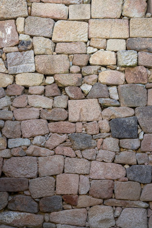 This image captures a richly textured stone wall echoing stories of the past, showcasing the remarkable artistry and the enduring nature of ancient building techniques.の写真素材