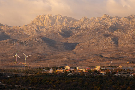 The majestic mountain range is illuminated by the warm glow of sunset, creating a captivating landscape bathed in rich colors that evoke a sense of wonder and beauty.の写真素材