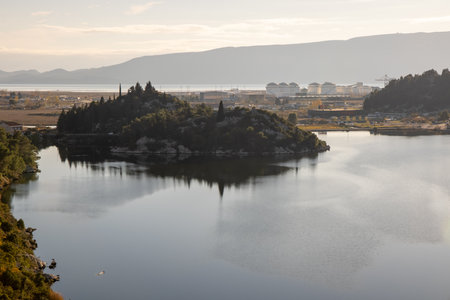 A tranquil scene featuring a small island reflected in calm waters, with lush vegetation, showcasing the serene beauty and harmony of natural landscapes.の写真素材