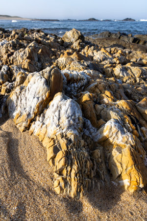 Close-up shot of a collection of rocks and sand.  The rocks exhibit a variety of textures, with some...