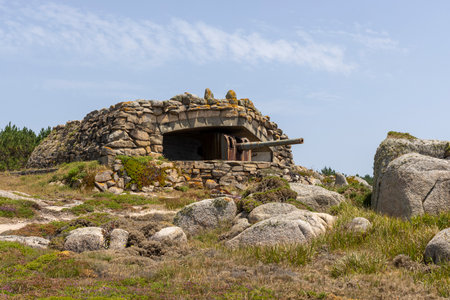 A large stone building with a gun on top of it. The building is surrounded by rocks and has a stone wall. Scene is one of strength and protectionの写真素材