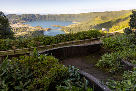 A beautiful view of a lake and mountains with a path leading to it at Sete Cidades, Azores. The path...