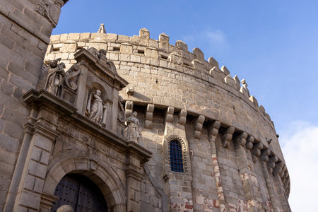 A large stone building with a clock tower. The building is old and has a lot of detail. The sky is...