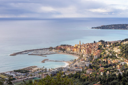 Menton city and harbor along the french riviera coastline, featuring historic buildings and azure seaの写真素材