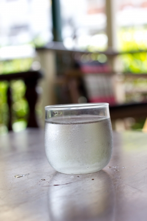 glass of water with ice on wooden tableの写真素材