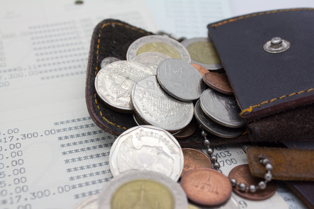 coins spilling out of open leather walletの写真素材