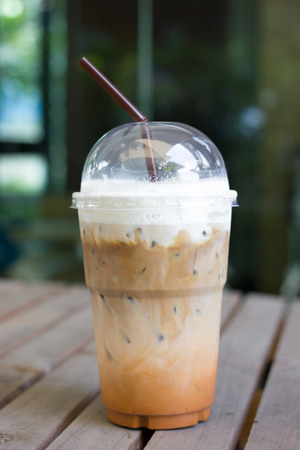 take-home cup of ice coffee on table.の写真素材