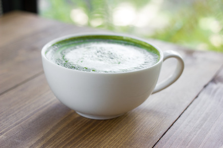 Matcha green tea latte beverage in glass on table.の写真素材