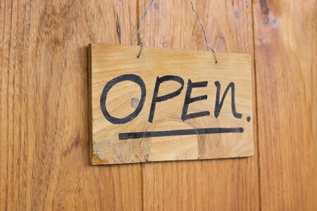 Vintage open sign on old wooden door.