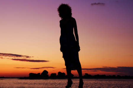 silhouette of slip of a girl on a background sunsetの写真素材