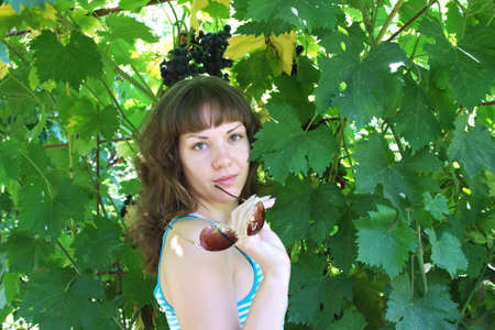 young girl on a background a vineの写真素材