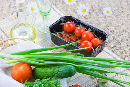 ripe red tomatoes and fresh greeneryの写真素材
