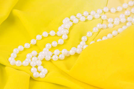 beads from white pearls on yellow fabric