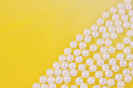 beads from white pearls on yellow fabric