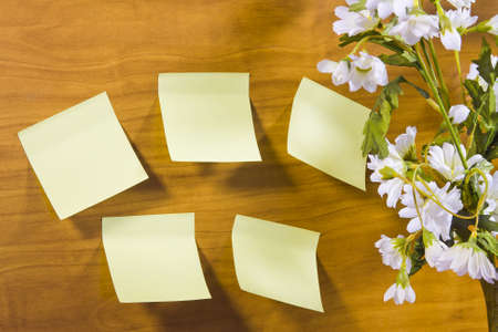 bouquet with camomiles and sticky sheets of paper on a wooden surfaceの写真素材
