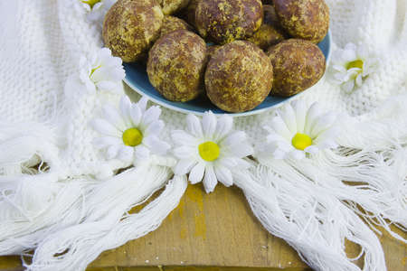 cakes on the white knitted fabric with a fringe and flowers of camomileの写真素材