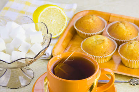 sweet vanilla domestic cakes, tea, lemon and vase with sugarの写真素材