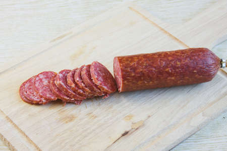 long loaf the smoked sausage on a wooden surfaceの写真素材