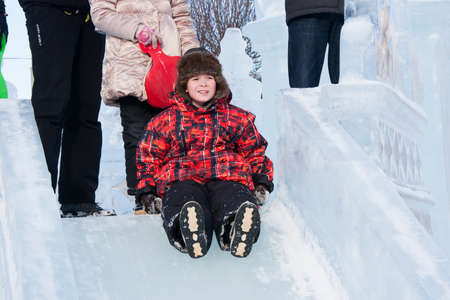 PERM, RUSSIA, Feb, 06.2016: Boy riding a frozen hill, urban esplanade, Lenin Streetのeditorial素材