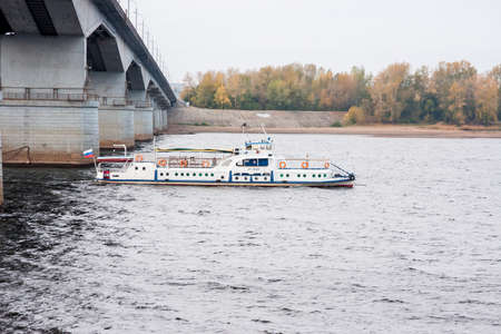 Perm, Russia - September 28,2016:  Walking boat leaves from under the bridge on the river Kama in the autumn eveningのeditorial素材