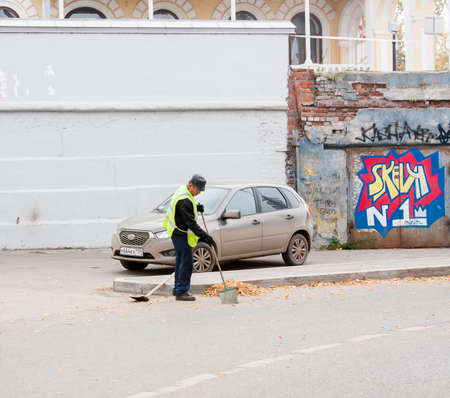 Perm, Russia - September 28.2016: Janitor cleans autumn leaves at the roadsideのeditorial素材