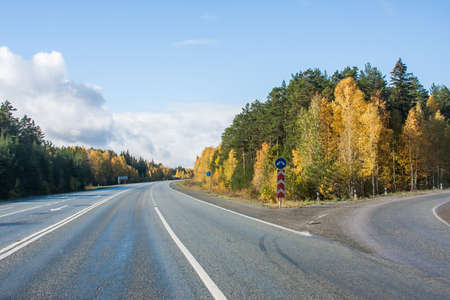 Revda, Russia - Autumn landscape with road, cars and beautiful blue skyの写真素材