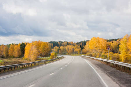 Revda, Russia -  Autumn landscape with road and the blue skyの写真素材
